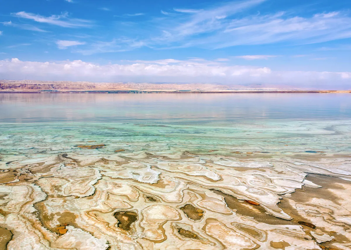 Salt crystals and calm blue waters along the Dead Sea shore