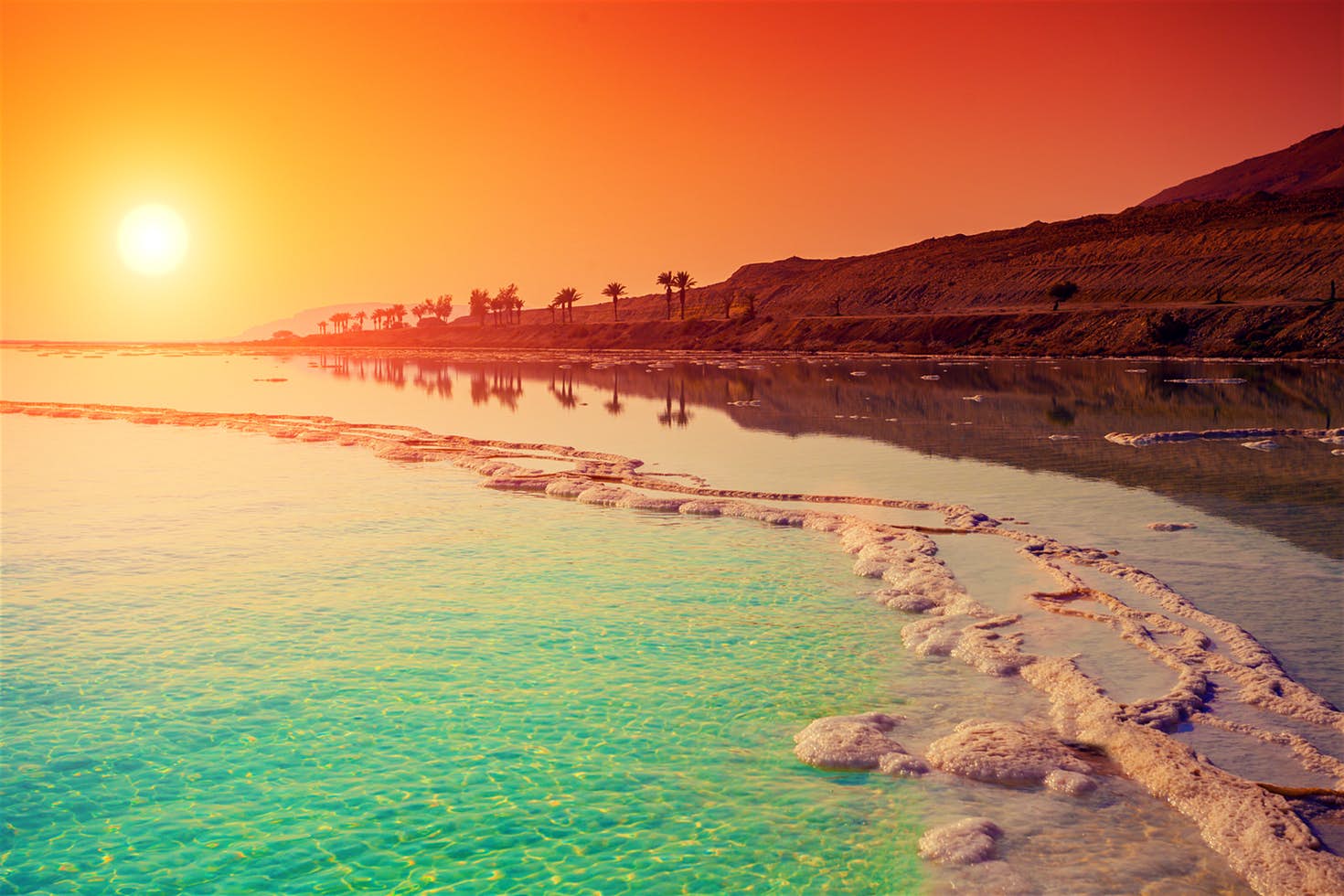 Salt crystals and calm blue waters along the Dead Sea shore